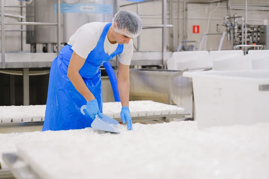 Operator working at a stainless steel dairy and beverage processing line