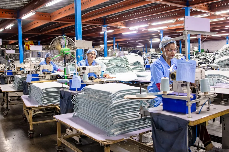 Sewing floor of a garment factory with pedestal and wall fans running