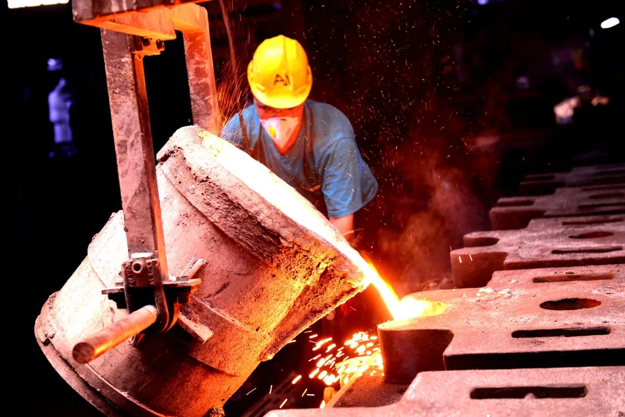 Foundry worker pouring molten metal, the kind of heat load a closed cooling circuit serves